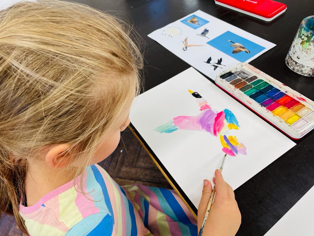 a picture of a girl painting a goose at Gold Geese workshop 2022